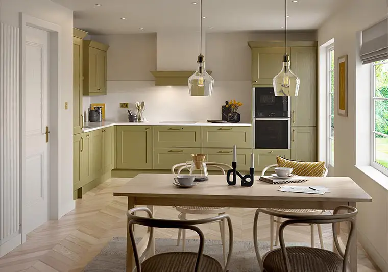 Olive green shaker kitchen with white quartz worktops and oak parquet flooring.