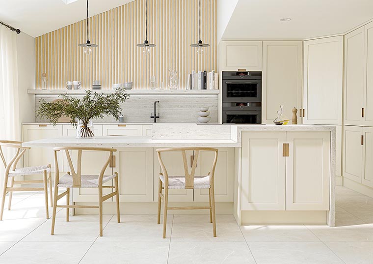 Cream shaker kitchen includes an integrated linear handle, white quartz and oak wall panelling.