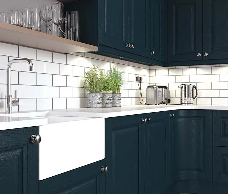 Dark blue shaker kitchen with belfast sink and white metro tiles, kitchen design and fit by James-Young Kitchens & Interiors.